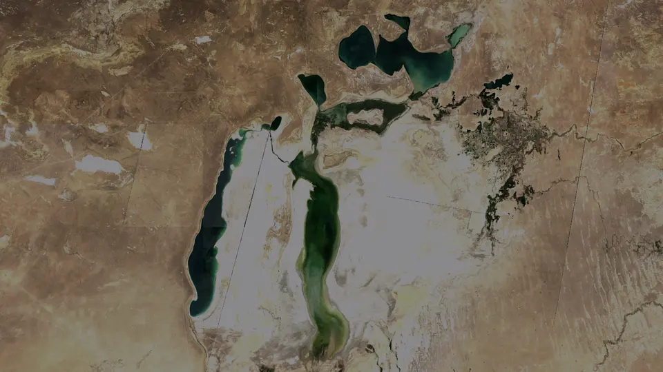 Satellite image from late summer 2017 of the Aral Sea: dark water in the North Aral and the western basin, with pale exposed seabed across the eastern basin.